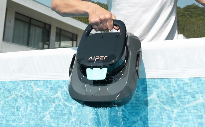 A Person Pulling Aiper Scuba SE Robotic Pool Cleaner Out of the Pool