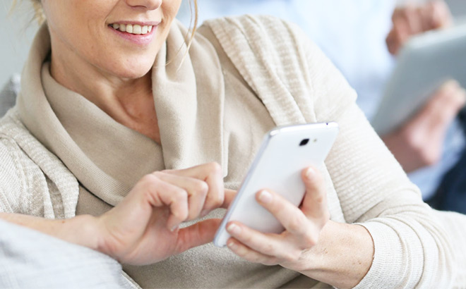 A Person Smiling and Typing on a Mobile Phone