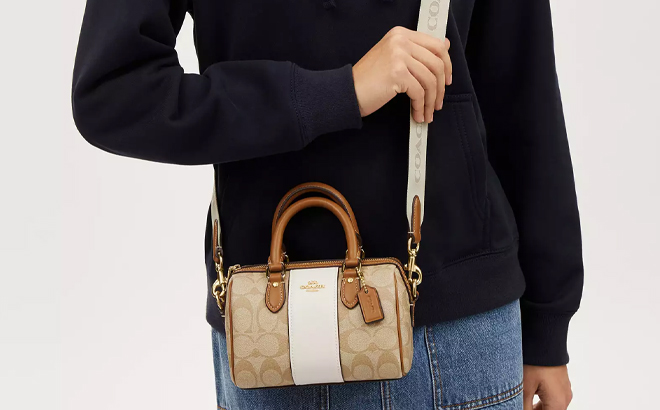 A Woman Wearing Coach Outlet Mini Rowan Crossbody In Signature Canvas With Stripe