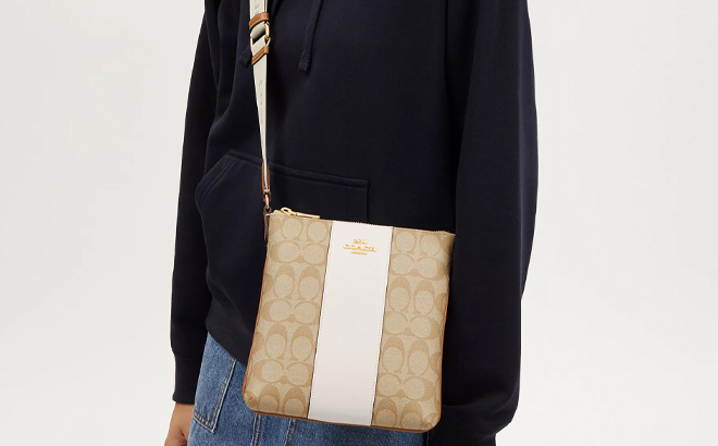 A Woman Wearing Coach Outlet Mini Rowan File Bag In Signature Canvas With Stripe