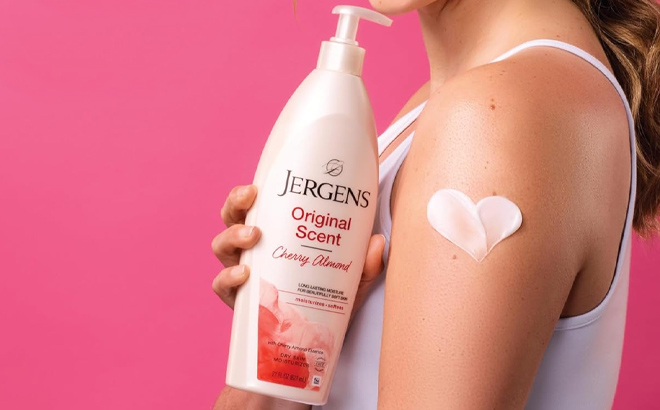 A lady holding a Jergens Original Scent Dry Skin Body Lotion