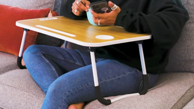 A person resting her arms on a Tech Impressions Portable Laptop Desk