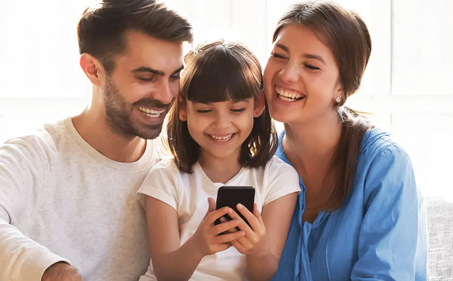 Family Smiling and Looking at a Mobile Phone