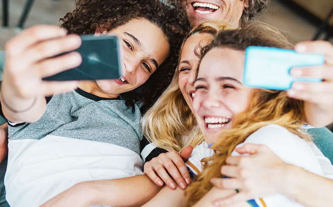 Family Taking Pictures with Mobile Phones and Smiling