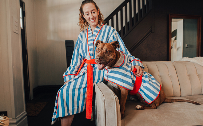 Woman And Her Dog Sitting on a Sofa Dressed in Matching Robes