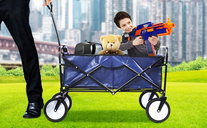 A Child HOlding a Toy Gun inside a Yssoa Rolling Collapsible Camping Wagon