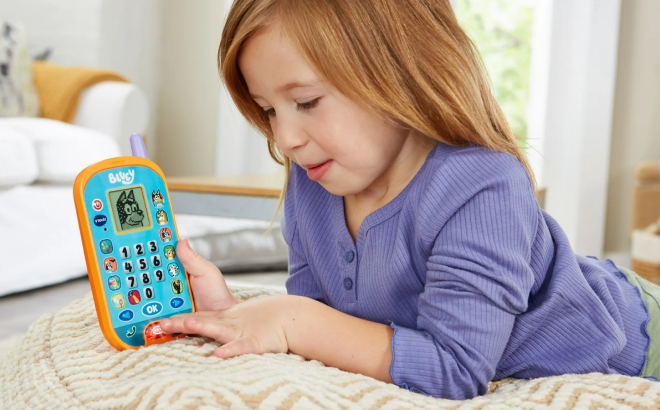 A Girl Playing with VTech Bluey Ring Ring Phone Toy