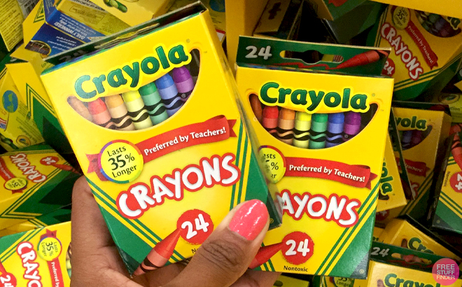 A Hand holding Two Boxes of Crayola Crayons 24 Count