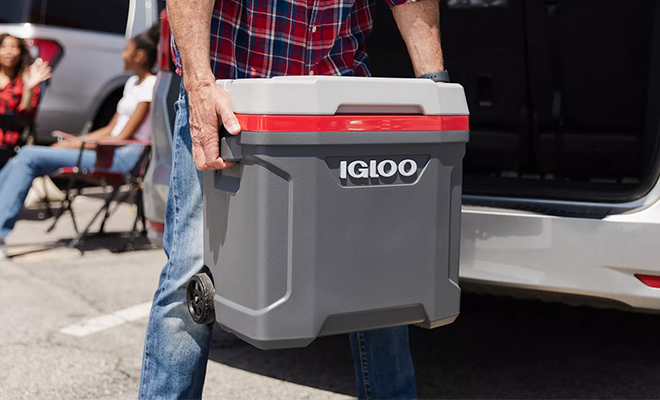 A Person Carrying the Igloo 30 Quart Latitude Roller Cooler in the Color Gray