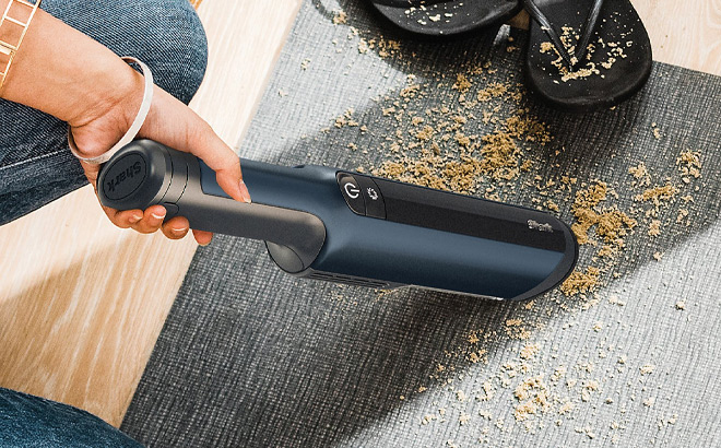 A Person Cleaning Floor with Handheld Vacuum