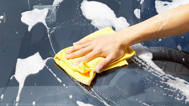 A Person Cleaning a Car Dashboard using a Amazon Basics Microfiber Cleaning Clothe