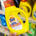 A Person Holding Tide Simply Odor Rescue Liquid Laundry Detergent