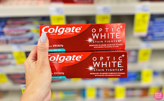 A Person Holding Two Colgate Optic White Toothpastes
