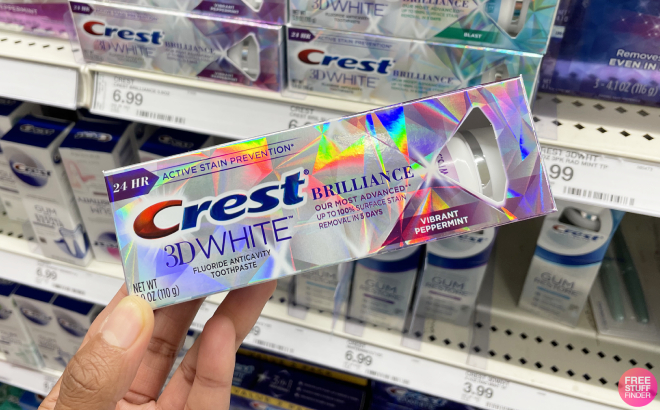 A Person Holding a Crest 3D White Brilliance Toothpaste
