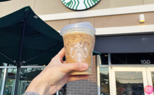 A Person Holing a Cup of Starbucks Coffee in Front of a Starbucks Store