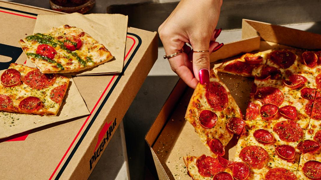 A Person Picking up a Slice of Pizza Hut Tavern Style Large Pizza