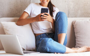 A Person Sitting on a Bed and Looking at a Mobile Phone