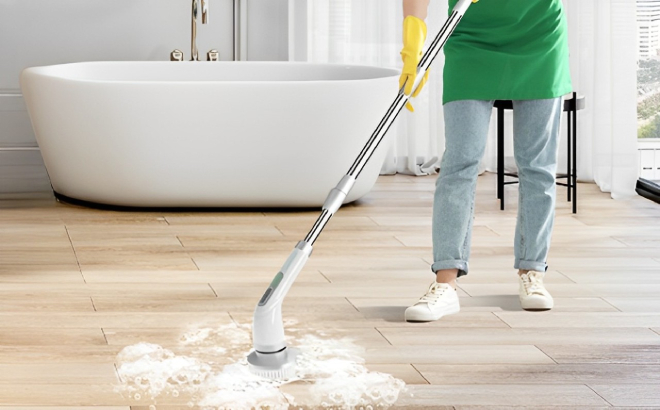 A Person Using an Electric Spin Scrubber to Clean Bathroom Floor
