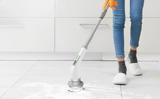 A Person Using an Electric Spin Scrubber to Clean the Floor