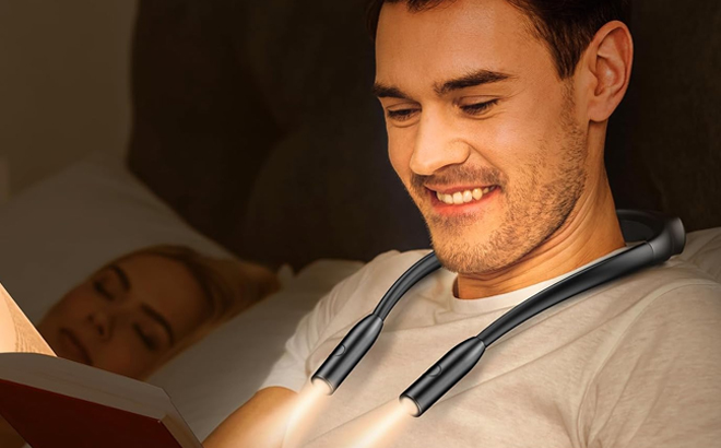 A Person Using the LED Neck Reading Light in Bed While Reading a Book