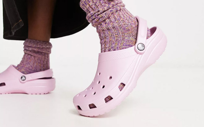 A Person Wearing Crocs Classic Clogs in Ballerina Pink Color