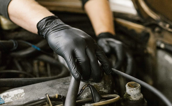 A Person Wearing Nitril Gloves while Fixing a Car