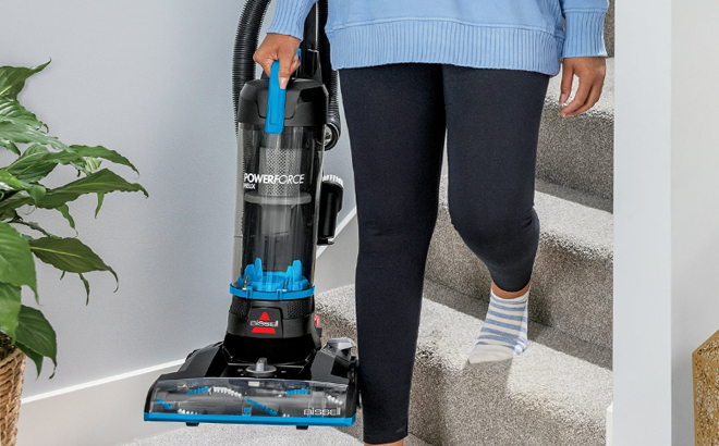 A Person carrying Bissell Upright Vacuum