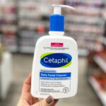 A Person holding a Bottle of Cetaphil 16 oz Daily Facial Cleanser