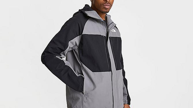 A Person wearing The North Face Trishull Windbreaker Full zip Mens Jacket in Smoked Pearl Color