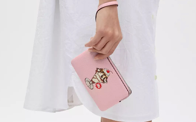 A Woman Holding Coach Outlet Corner Zip Wristlet With Sundae Graphic