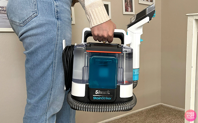 A Woman Holding Shark StainStriker Portable Stain Remover