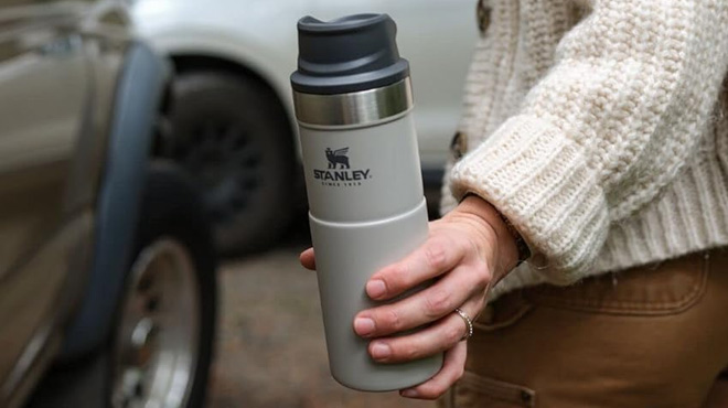 A Woman Holding Stanley 16 Ounce Trigger Action Vacuum Mug