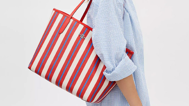A Woman Wearing Coach Outlet City Tote Bag With Stripe Print