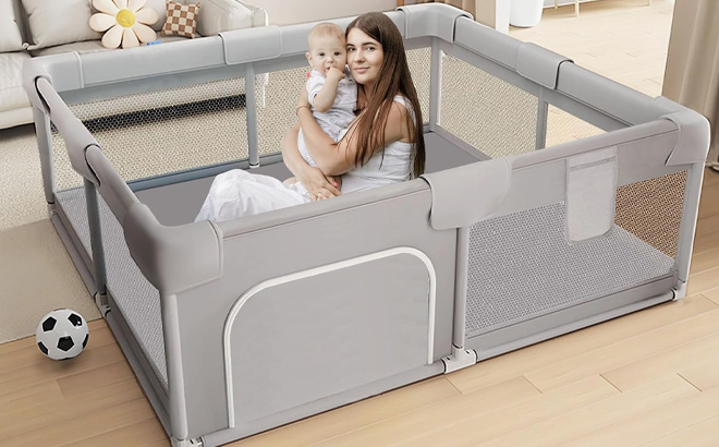 A mother holding her child inside a Hiaksedt Baby Playpen