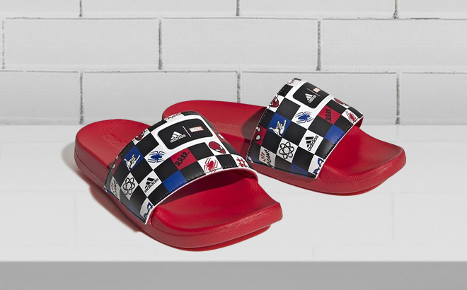 Adidas Kids Adilette Comfort Spiderman Slide Sandals on the Table