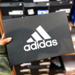 Hand holding Adidas shoe box