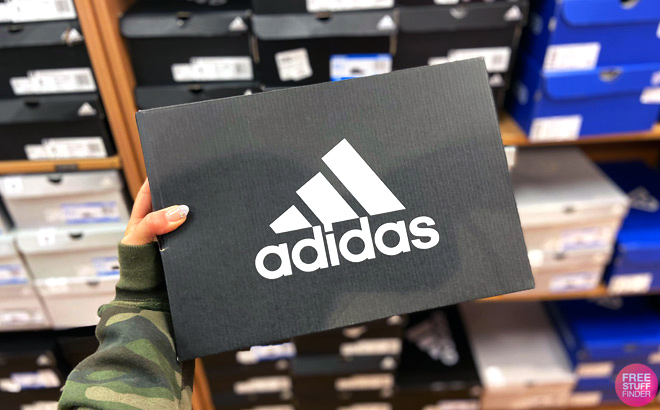 Hand holding Adidas shoe box