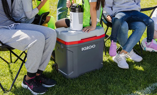 People Sitting Around the Igloo 30 Quart Latitude Roller Cooler in the Color Gray