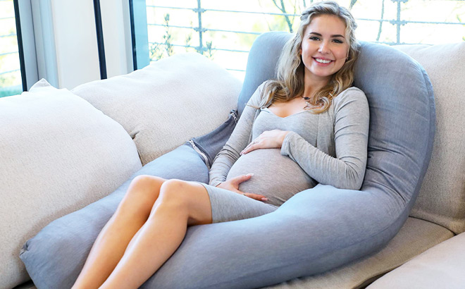 Woman Sitting on U Shaped Body Pillow on the Couch