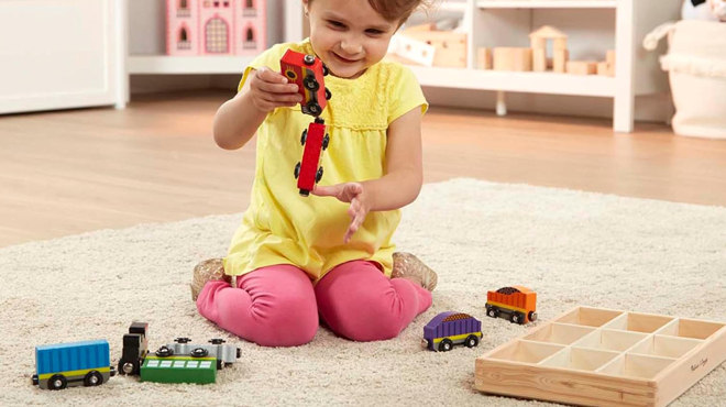 A Child Playing with Melissa Doug Wooden Magnetic Train Cars