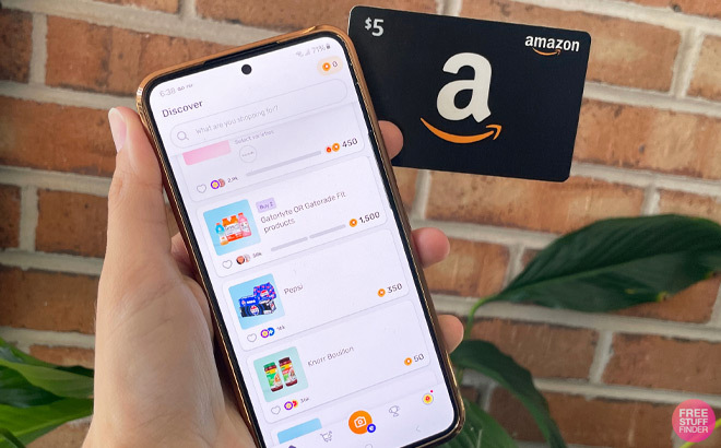 A Hand Holding An Amazon Gift Card and Phone with Fetch App