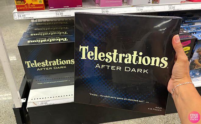 A Hand Holding Telestrations After Dark Board Game