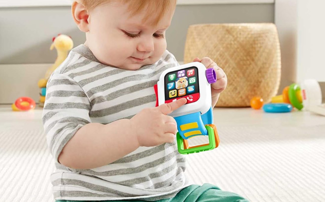 A Kid Holding Fisher Price Laugh Learn Baby to Toddler Toy Time to Learn Smartwatch