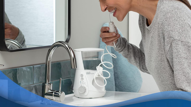 A Person Flossing with a Waterpik Aquarius Water Flosser