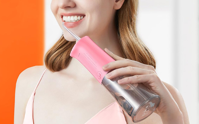 A Person Holding Bitvae Water Flosser Teeth Picks in Quartz Pink Color
