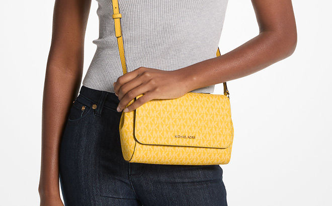 A Person Holding Michael Kors Medium Logo Convertible Crossbody Bag in Yellow Color