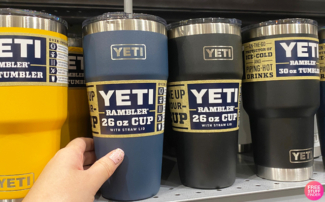 A Person Holding YETI Rambler 26 Ounce Straw Cup on a Shelf