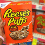 A Person Holding a Box of Reeses Puffs Cereal