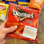 A Person Holding a Doritos Flavored Tortilla Chips in Nacho Cheese Flavor