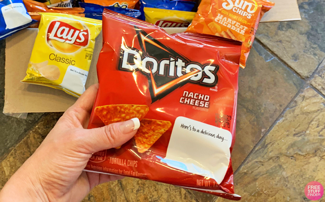 A Person Holding a Doritos Flavored Tortilla Chips in Nacho Cheese Flavor